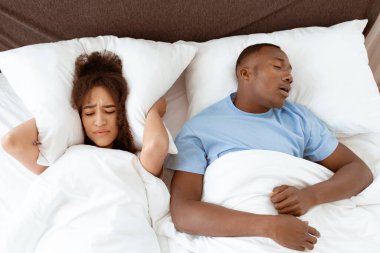 Apne, çıldırmış, horlama uykusuzluğu çekiyor. Koca yüksek sesle horluyor ve sinirli genç afro-amerikan karısı gürültüden uyuyamıyor, bayan kulaklarını yastıkla örtüyor, üst manzara, boş alan