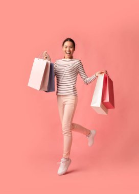 Büyük Satış Konsepti. Pembe Arkaplanda Renkli Alışveriş Torbalarıyla Koşan Mutlu Asyalı Kadın, Heyecanlı Koreli Alışverişkolik Kadın Mevsimsel İndirimlerden Hoşlanıyor, Kopyalama Alanı