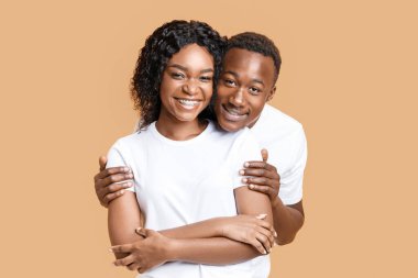 Neşeli siyahi adam arka plandaki mutlu kız arkadaşına sarılıyor, fotokopi odası. Gülümseyen Afro-Amerikan çift kameraya poz veriyor. Aşk, ilişkiler, aile kavramı