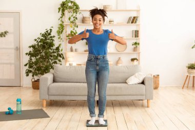 Başarılı Kilo Verme. Neşeli Afrikalı Kız Parmak Kalkmış, Ağırlığını İçerde Ağırlık Dengeleyerek Ağırlığını Kaldırıyor. Tam Uzunluk, Boşluğu Kopyala