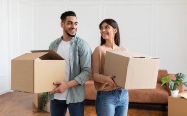 Sevgi dolu çift birlikte karton kutular taşıyor, sırt sırta durup taşınma gününde oturma odasında birbirlerine bakıyorlar. Genç kiracılar eşyalarıyla yeni bir daireye taşınıyor, eşyaları boşaltıyorlar.