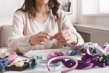 Yapma, home atölye el yapımı saç bantları. Tanınmayan kadın esnaf saç çember çiçek ve kurdeleler ile dekorasyon. Sanat, el sanatları, yaratıcı kavramı