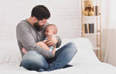 Endişeli baba tutarak onun kollarında şirin yeni doğan bebek ağlıyor ve onu, lulling kopyalama alanı