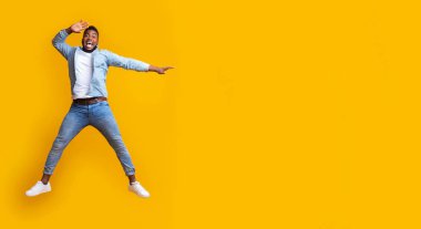 İnanılmaz bir teklif. Duygusal afro adam zıplıyor ve el ve sarı arka planla fotokopi alanını işaret ediyor.