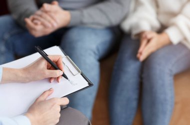 Aile Psikologu. Profesyonel Evlilik Danışmanı ofiste oturan bir çiftle notlar alıyor. Seçici Odaklanma, Kırpılmış