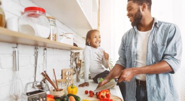 Sevimli küçük afro kız ve babası evde mutfakta yemek. Mutlu aile pişirme konsepti