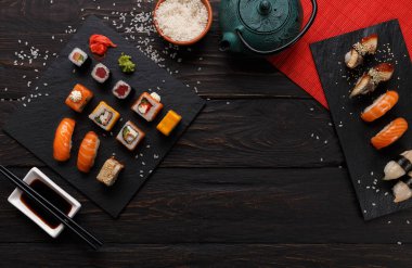 Suşi ve rulo arka plan, siyah, en iyi görünümü karede. Renkli Japon restoran yiyecek çay ile ayarla