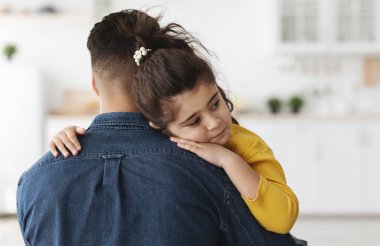 Yakın plan, babasını önemseyen üzgün küçük Arap kızı, Orta Doğulu sevimli bir kızın babasına sarılmasının, ebeveynlerin desteğini ve korumasını hissetmesinin,