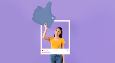 Sıradan sarı tişörtlü genç bir kadın, büyük bir grafikle poz verirken parlak bir şekilde gülümsüyor..