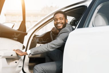 Gülümseyen siyah işadamı arabadan iniyor, ofise geliyor, yer kopyası