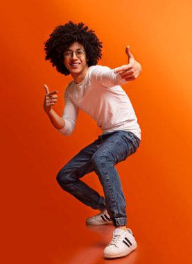 Gotcha Duygusal bin yıllık adam kamera, tam uzunlukta, turuncu stüdyo arka plan parmakları işaret,