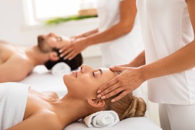 Birlikte kafa masajı yapan çift kapalı kaplıcalarda gözleri kapalı yatağında uzanıyorlar. Sağlık ve Rahatlama Prosedürü, Güzellik Spa Günü Konsepti. Seçici Odaklanma