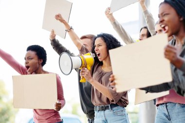 Boş pankartlar ve megafonla sokaklarda protesto yapan çok ırklı göstericiler. İnsan hakları için savaşan uluslararası bir grup insan, boş tahtalar ve yan görüş gösteriyor
