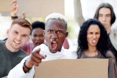 Sokaklara saldıran, ellerinde boş pankartlarla kamerayı işaret eden mutiryaki bir grup gösterici. Uluslararası göstericiler ırkçılığa karşı mücadele ediyor, kentten geçerek sloganlar atıyorlar.