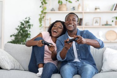 Duygusal Afrikalı aile babası karı koca evdeki oturma odasında video oyunu oynuyorlar, boşluğu kopyalıyorlar.
