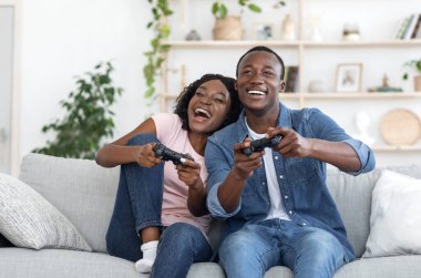 Duygusal Afrikalı aile babası karı koca evdeki oturma odasında video oyunu oynuyorlar, boşluğu kopyalıyorlar.