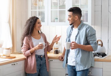 Ev Tatili. Neşeli bir Orta Doğulu çiftin birlikte mutfakta vakit geçirmelerinin portresi, mutlu bir Arap erkek ve kadının sabah kahvesini içip sohbet etmeleri, ev içi eğlencelerin, boş zamanların keyfini çıkarmaları,