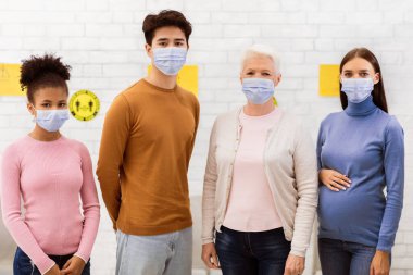 Coronavirus aşısı. Covid-19 grubu yüz maskeli çeşitli hastaları aşıladı, hastanede kameraya bakıyorlar. Kapsamlı Enfeksiyon Bağışıklığı, Corona Virüs Aşısı Konsepti