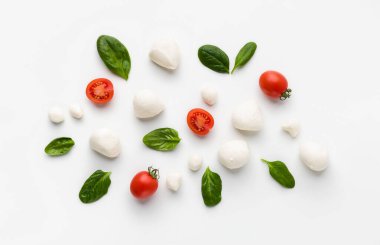 Beyaz arka planda kiraz domatesinden, fesleğenden ve peynirden yapılmış renkli kapuçin karışımı. Caprese salata konsepti