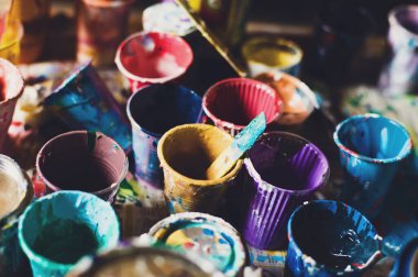 Boyalı çok renkli plastik kanlar. Sanatçı işyeri arka planı. Sanat aletleri. Eski kirli Boyalar arka plan. Renkli sanatçı paleti. Yumuşak tonlu. Yaratıcılık, görsel sanat konsepti. Sanat ve zanaat. Closeup