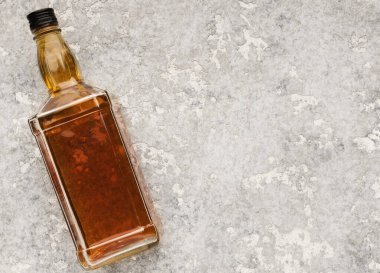 Gri taşlı arka planda elit alkol şişesi. Viski, konyak ya da konyak reklamı için maket, üst görünüm, kopyalama alanı