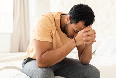 Erkek Depresyonu. Yüzü örten mutsuz Orta Doğulu adam evde yatak odasında otururken stres ve sorunlar yaşıyor. Depresif düşüncelerden muzdarip tanınmaz bir adam. Akıl Sağlığı Konsepti