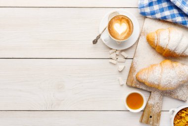 Geleneksel Fransız kahvaltı menü arka plan. Krema, fincan kahve, müsli ve ahşap masa, üstten görünüm, bal ile taze kruvasanlar alanı Kopyala