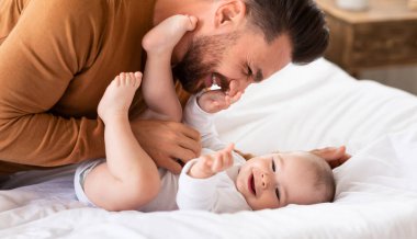 Sevimli bir baba, küçük kızına sarılıp evde yatarak vakit geçiriyor. Babacığının yeni yürümeye başlayan çocukla gülmesine bayılıyorum. Babalık, Babalık Sevgisi, Çocuk Bakımı ve Ebeveynlik neşesi