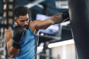 Spor salonunda boks antrenmanı. Boks torbasını yumruklayan sporcu, serbest alan.