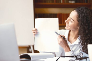 Yeni Tema Açıklanıyor. Gülümseyen İngilizce öğretmeni portresi dizüstü bilgisayarda sanal konferans veriyor, öğrencilere online ders veriyor. Boş kağıda bakan kadın, webcam 'e gösteriyor