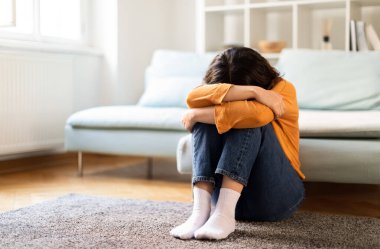 Depresyon Konsepti. Orta Doğulu üzgün bir kadının evde ağlamasının portresi, depresif bir milenyum kadınının kafası yerde otururken diz çökmesi, ruhsal çöküntüye uğraması, boşluğu kopyalaması...