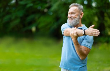 Mutlu kıdemli adam eğitiminin portresi, Yeşil Park 'ın dışında dururken kaslarını esneten yaşlı adamın gülümsemesi, sağlıklı yaşam tarzının keyfini çıkaran olgun bir erkek, kopyalama alanı.