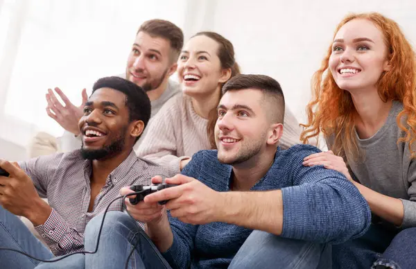 Neşeli arkadaşlar video oyunlarında yarışıyor, evde birlikte eğleniyorlar.