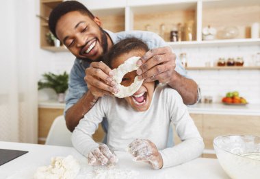 Afro amerikan adam ve küçük kız birlikte pasta pişirme, eğlenmek