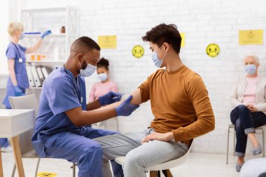 Coronavirus aşısı. Klinikte doktor randevusu sırasında Çinli hasta Covid-19 aşısı yaptırıyor. Corona Virüs Nüfus Bağışıklık Kampanyası, Covid 19 İlaç Tedavisi