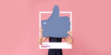 Bir insan parlak pembe bir arkaplan önünde büyük bir işaret tutuyor. Bu canlı gösteri, içerik oluşturma konusunda coşkulu bir şekilde sosyal medyanın katılımını vurguluyor..