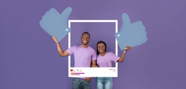 İki neşeli nüfuzlu kişi, mor bir arkaplan karşısında, takipçileri için çevrimiçi içerik oluşturma konusundaki başarılarını kutlamak için, büyük baş parmaklı işaretlerle poz veriyorlar..