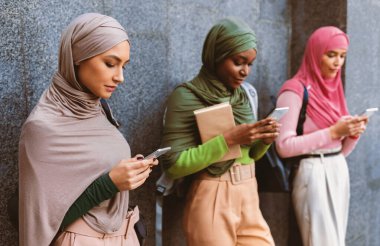 Modern Arap Kadınlarının Akıllı Telefonları Kullanması Cep Telefonu Uygulamaları Sosyal Medya Ağı Dışarıdaki Gri Duvar 'ın Üzerinde Durmakta. Cep telefonlu kadın Müslüman Öğrenciler Uygulamaları Kullanıyor