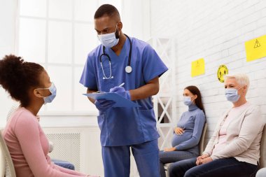 Coronavirus Aşılama Konsepti. Afro-Amerikalı doktor, Covid-19 aşısından önce Hasta Kız ile konuşuyor. Hastanede oturuyor. Corona Virüs Koruma ve Tıbbi Dokunulmazlık