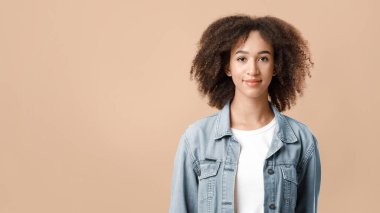 Güzel gülümseyen genç bayan. Şirin kıvırcık Afrikalı Amerikalı kadın, rahat, mutlu ve tasasız, yüzünde pozitif neşeli bir ifade var, sarı arka planda izole edilmiş, kopya alanı, stüdyo çekimi