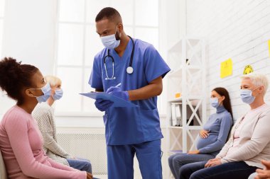 Afrikalı doktor ve hasta maskeli kız Coronavirüs belirtileri hakkında konuşuyor. Covid-19 aşısı hastanede yapılmadan önce. Corona Virüs Aşısı, Kapsamlı Bağışıklık Kampanyası Konsepti