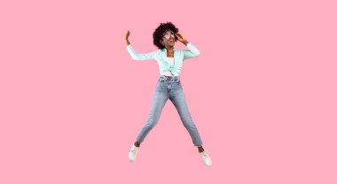 Pembe Stüdyo Arkaplanı 'nın üzerinde güneş gözlüğü takan neşeli, Afro-Afrikalı, kıçı kalkık bir kadın. Summer Vibe, Neşe ve Mutluluk, Pozitif Duygular Konsepti. Tam Uzunluk Çekimi