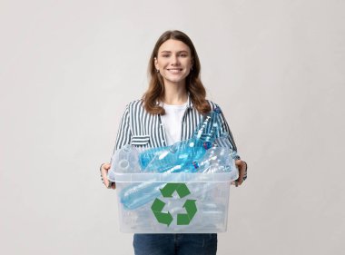 Plastik Geri Dönüşüm. Milenyum Kadını Şişeleri Geri Dönüşüm İçin Tutuyor, Gri Arkaplanda Sıfır Atık Yaşam ve Çöp Ayıklama İçin Telaşlanan Genç, Çevre dostu Bayan