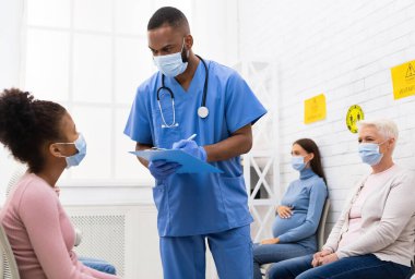 Coronavirus Aşılama Konsepti. Afro-Amerikalı doktor, Covid-19 aşısından önce Hasta Kız ile konuşuyor. Hastanede oturuyor. Corona Virüs Koruma ve Tıbbi Dokunulmazlık