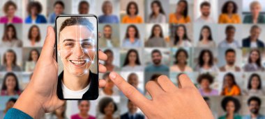 Bir kişi elinde yüz tanıma teknolojisini gösteren bir akıllı telefon tutuyor. Ekranda gülümseyen bir yüz ve dijital bir kaplama var. Birçok portre arka planı doldurarak, farklı bireyleri vurguluyor.