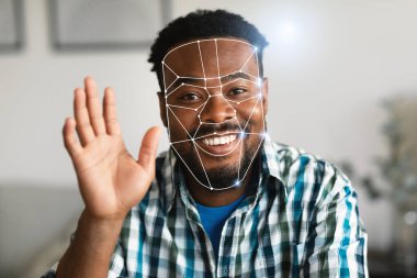 Yüzünde neşeli bir ifade olan Afro-Amerikalı bir adam yüz tanıma kontrolüne katılıyor. Gelişmiş teknoloji, yeni normal yaklaşımını sergileyerek onun yüz hatlarını ön plana çıkarıyor.