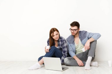 Çevrimiçi sipariş. Yeni dairede beyaz arka planda otururken yemek servisini arayan bir çift.