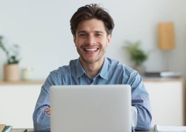 Başarılı Freelancer. Mutlu adam evde laptop oturan kamera gülümseyen. Seçici Odak