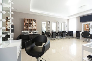 Güzellik salonunun ön planında müşteriler için berber koltuğu
