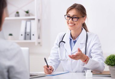 Phisicians Ziyaret. Ofiste Otururken Tanınmayan Hasta ile Konuşan Neşeli Bayan Doktor